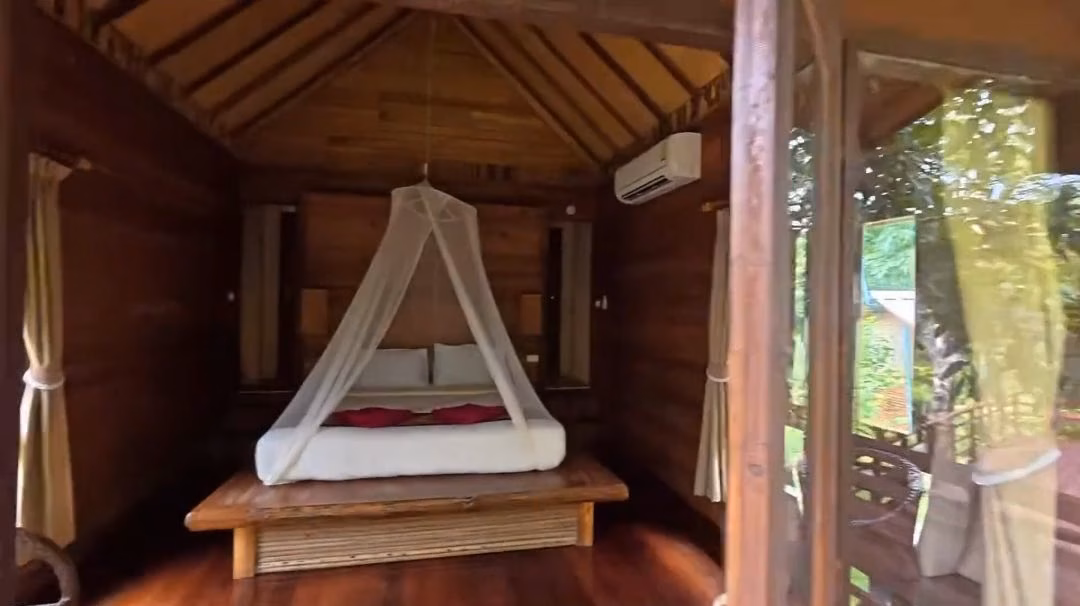 Room at The Cliff & River Resort with a mosquito-net bed and air-conditioning